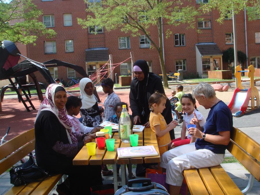 Folk på en bænk i Mjølnerparken på Nørrebro. Foto: Nørrebro Bibliotek 